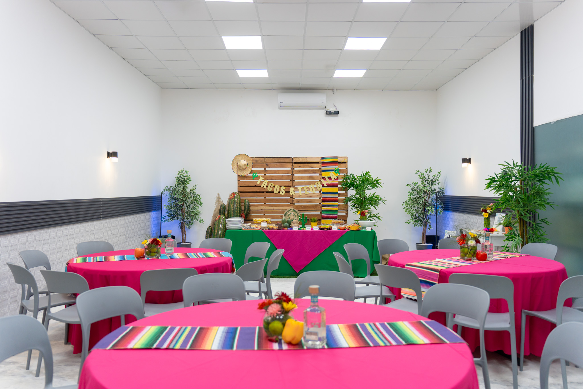 Salón de eventos versátil y espacioso para capacitaciones y conferencias, con pantalla y sillas organizadas